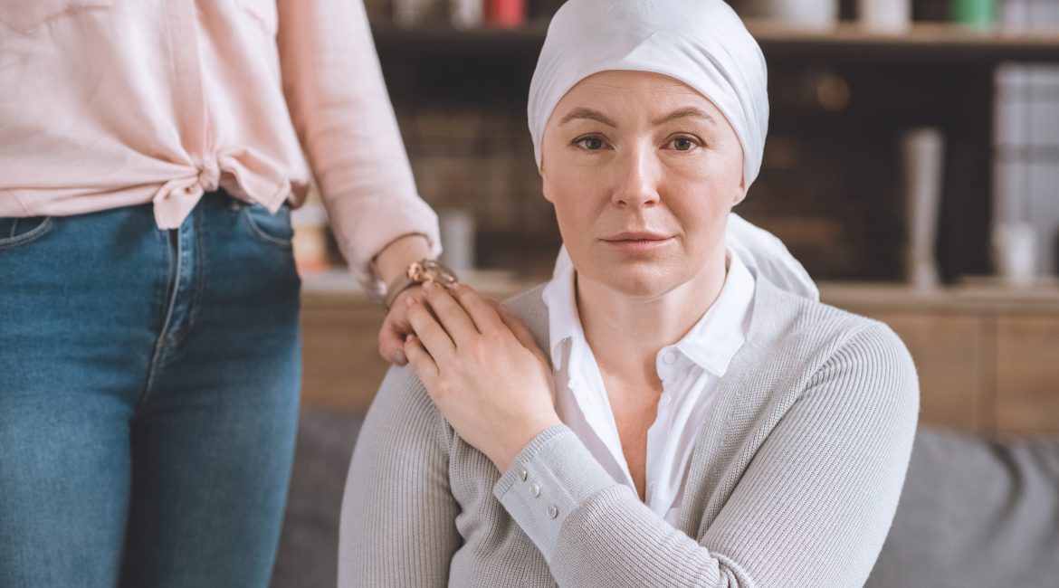 žena podporuje chorú matku na rakovinu v šatke pri pohľade na fotoaparát
